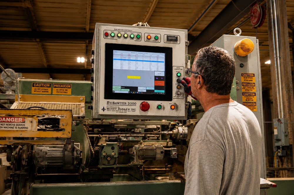 Longhorn Truss team member operating a computerized cutting station in the shop.